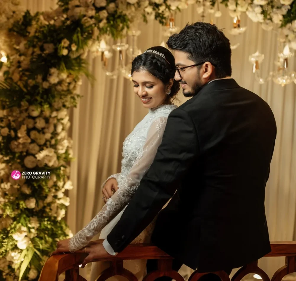 Bride and groom standing under arch decorated with flowers